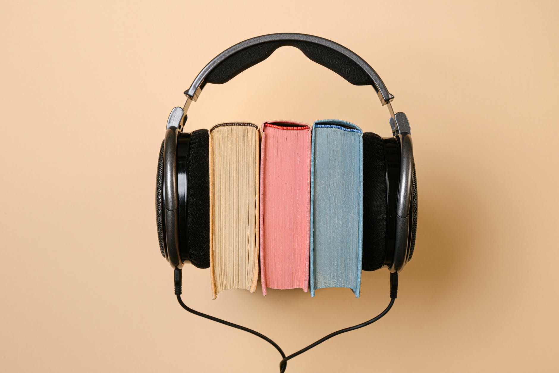 black corded headphones with colorful books in between